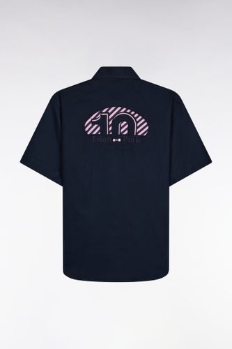 Cette chemise manches courtes arbore une broderie d'inspiration rugby dans le dos et l'emblème nœud papillon brodé sur la poitrine. Une pièce fort - Eden Park - Modalova
