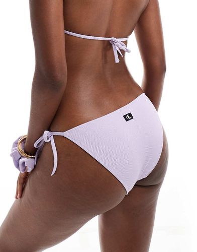 Bas de bikini texturé noué sur les côtés avec monogramme CK - Lilas pastel - Calvin Klein - Modalova