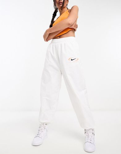 Pantalon de jogging parachute tissé à logo virgule - Nike - Modalova