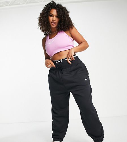 Nike - Pantalon de jogging large à taille haute avec petit logo virgule -  Rose
